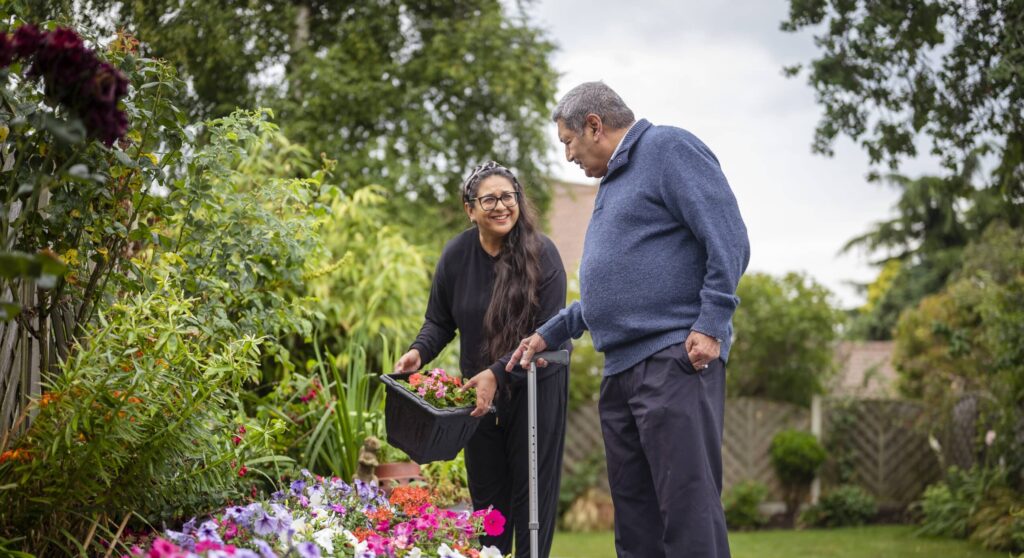 Two aging adults interacting in a garden